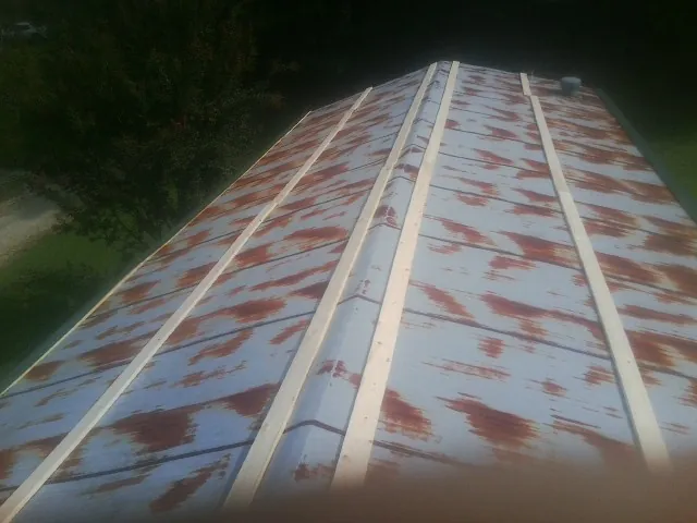 Rusted metal roof panels with new wood purlins before replacement — Storm Damage Roof Repair in Aredale by Roofing Brothers